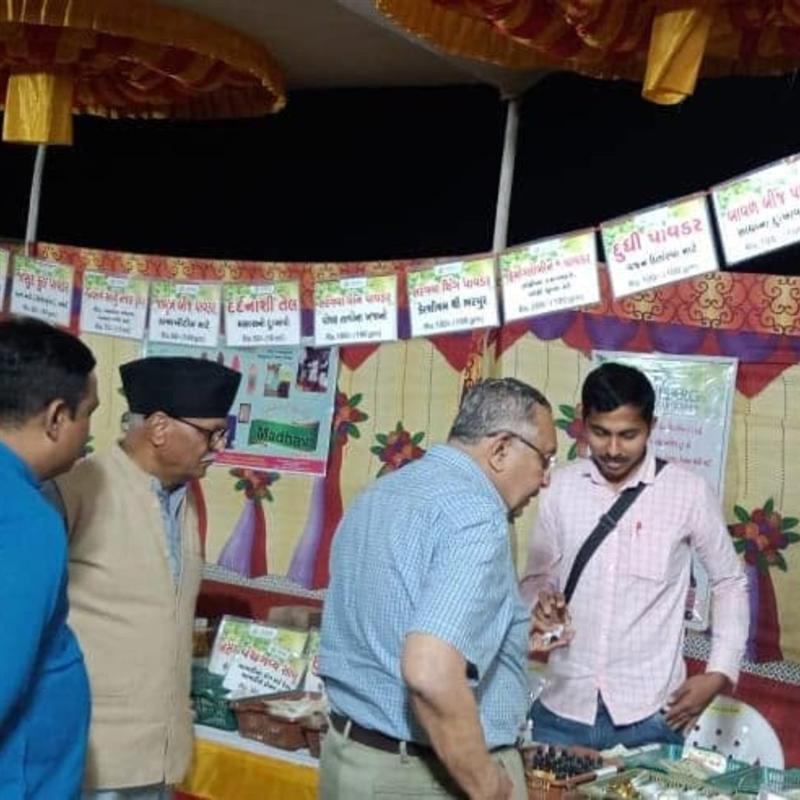 Visitors learning about organic herbal products at the Nisarg Organic Farm exhibition stall
