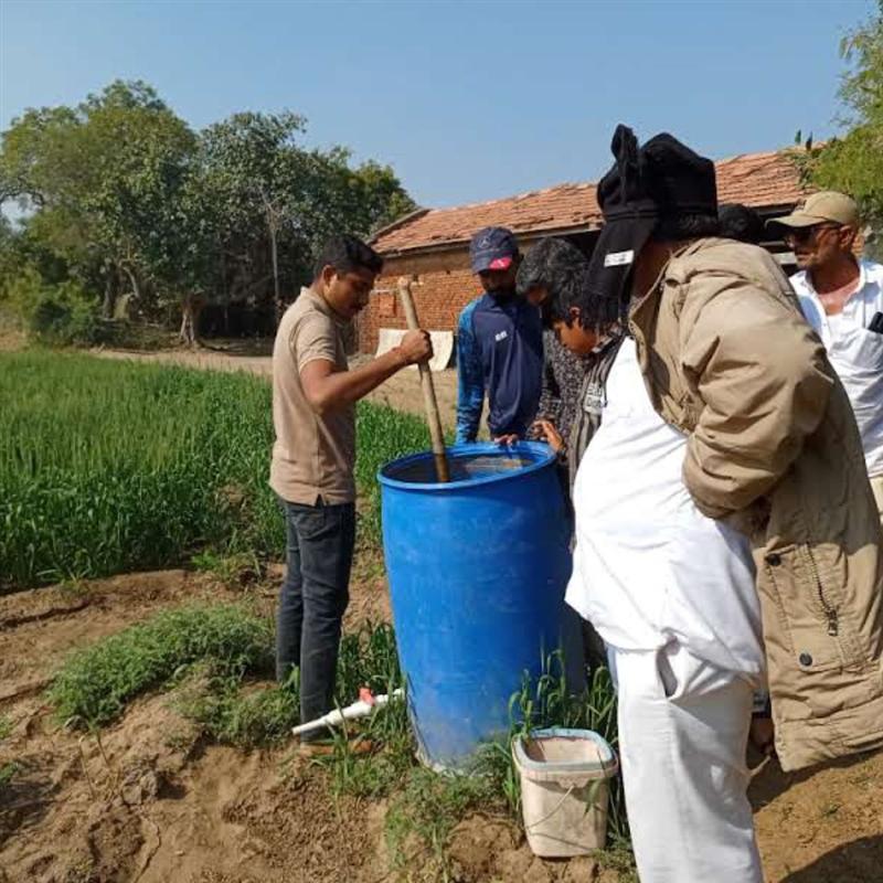 Farm workers preparing natural organic inputs for herb cultivation at Nisarg Organic Farm