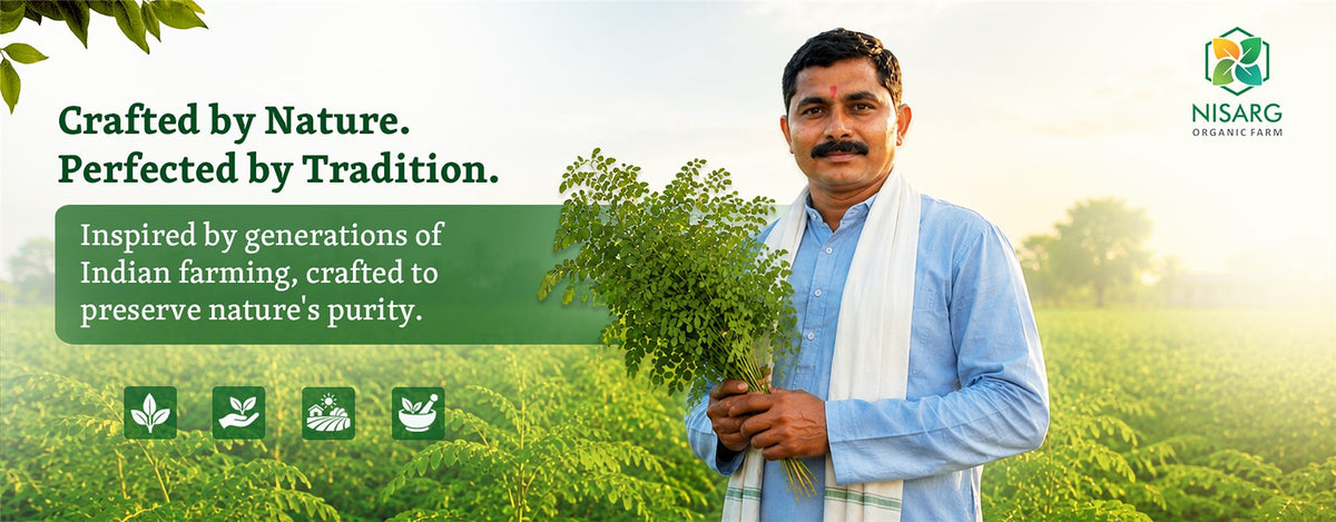 Crafted by nature, perfected by tradition - farmer holding fresh moringa leaves | Nisarg Organic Farm